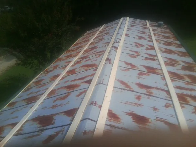Rusted metal roof panels with new wood purlins before replacement — Storm Damage Roof Repair in Milltown by Roofing Brothers