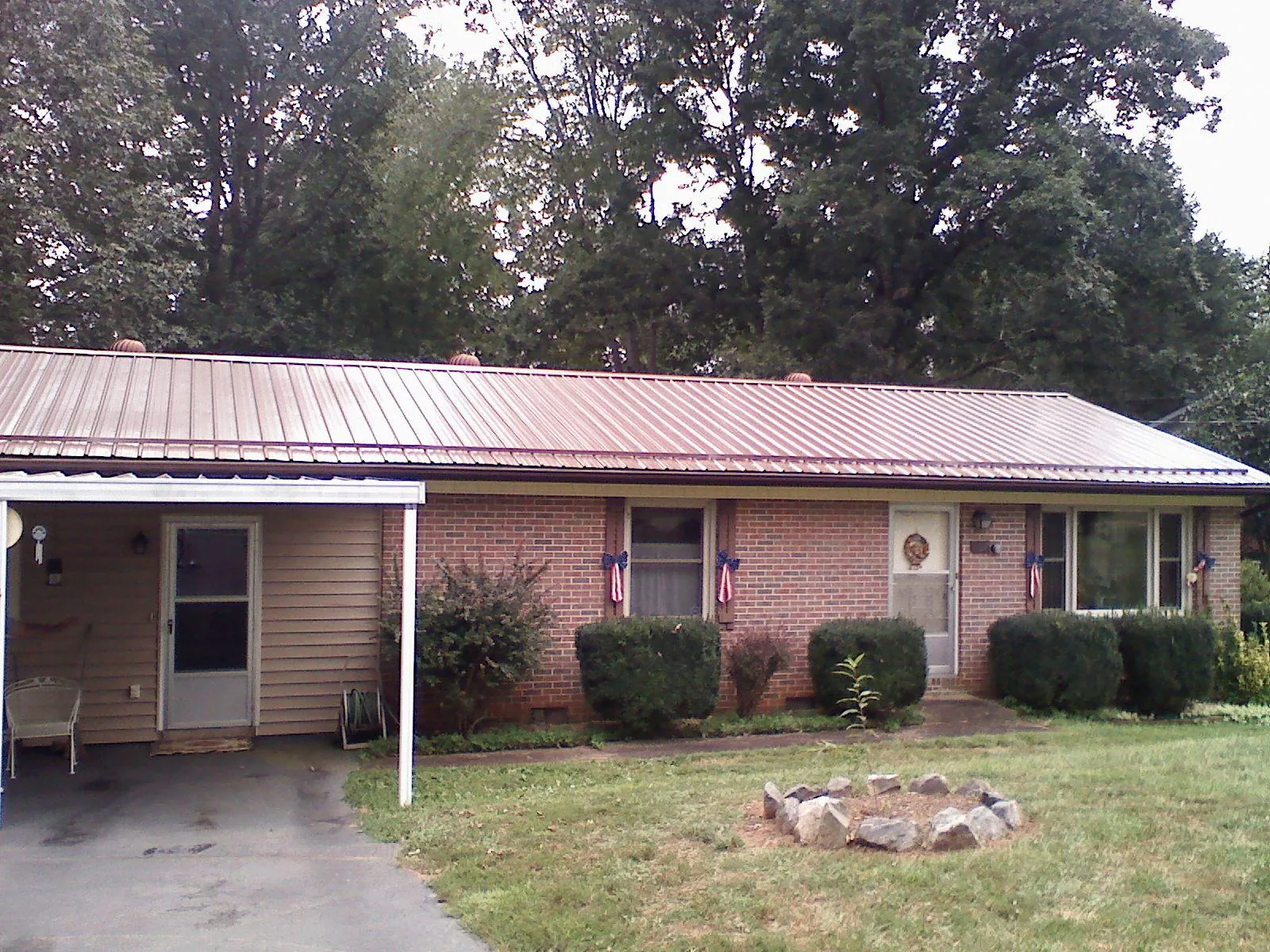 Bronze metal roof and carport on a brick ranch home — Roof Repair work by our crew in Milltown